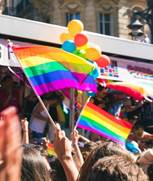 people holding yellow, green, blue, and purple flag